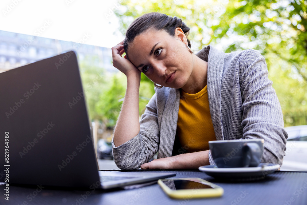 Worried businesswoman staring at laptop