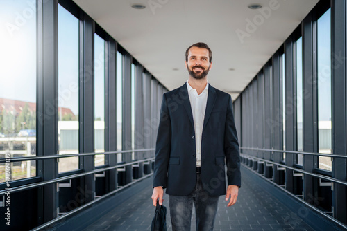 Wallpaper Mural Smiling businessman with bag walking on elevated walkway Torontodigital.ca