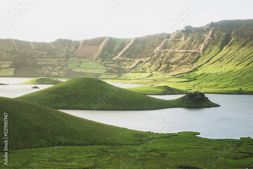 Idyllic view of lake amidst green hills on sunny day photo