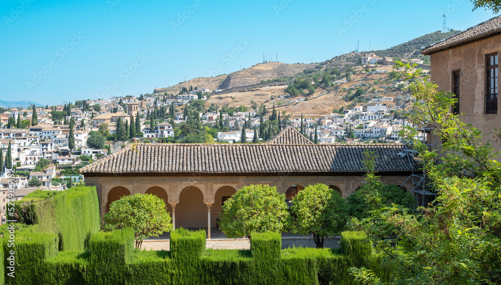 Fototapeta premium El patio de Machuca en el recinto de la Alhambra con la ciudad de Granada al fondo, España