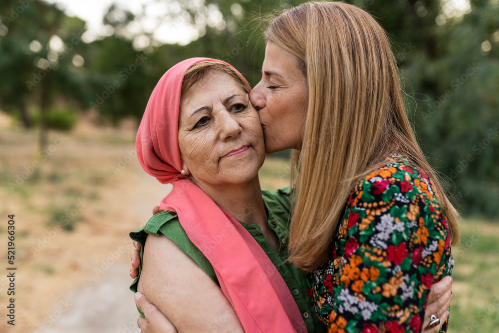 Daughter kissing mother at park