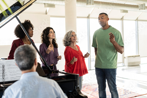 Businessman singing by colleagues snapping fingers in office