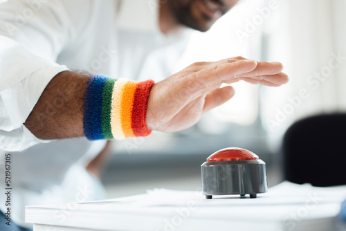 Businessman with hand poised on game show buzzer at office photo