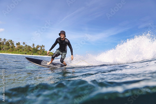 Man wearing hat surfing in sea on sunny day photo