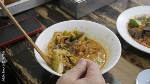 man eating famous traditional kanom jeen with soicy base soup, food in lana chiang mai taste rice noodle with soup style. Local Thai style food with local ingredients base soup photo