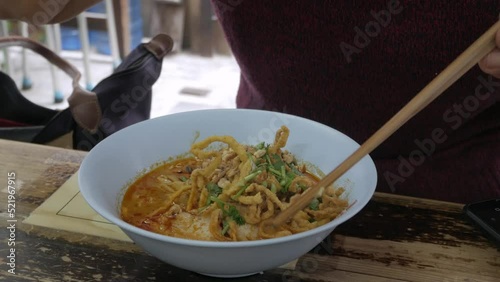 man eating famous traditional kanom jeen with soicy base soup, food in lana chiang mai taste rice noodle with soup style. Local Thai style food with local ingredients base soup photo