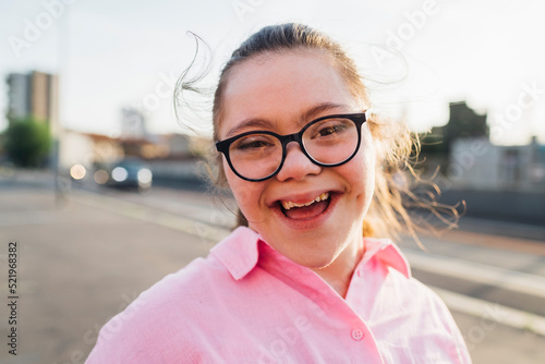 Happy teenage girl with down syndrome wearing eyeglasses photo
