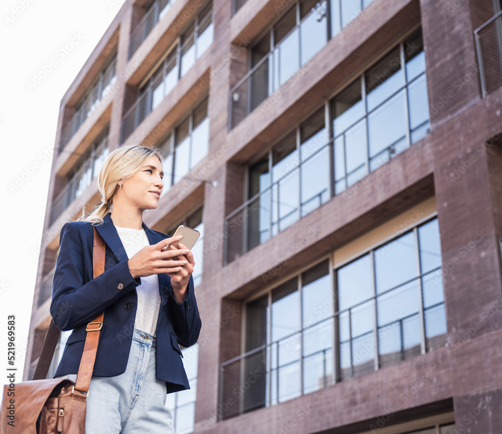 Smiling young woman with mobile phone standing in front of building Smiling young woman with mobile phone standing in front of building