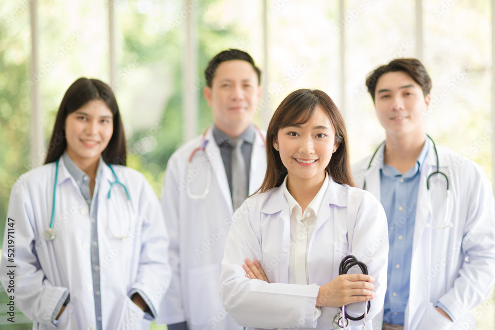 Group of Asian doctors team portrait standing with colleagues in background. Group of Asian doctors team portrait standing with colleagues in background.