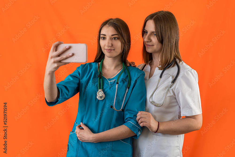 two beautiful young female nurses standing smiling in med uniform on isolated background two beautiful young female nurses standing smiling in med uniform on isolated background