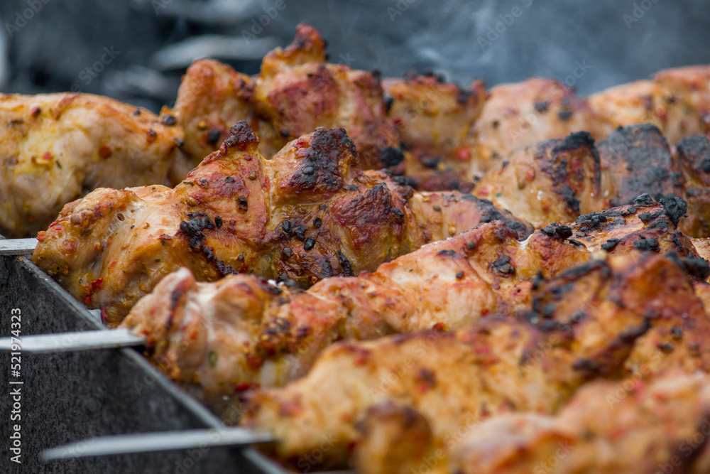 Marinated shashlik preparing on barbecue grill over charcoal.