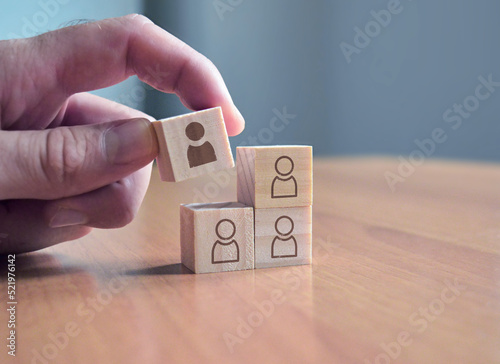 Hand holding a block diplaying a new member of the team - Business solutions for teams, complete puzzle, missing block photo