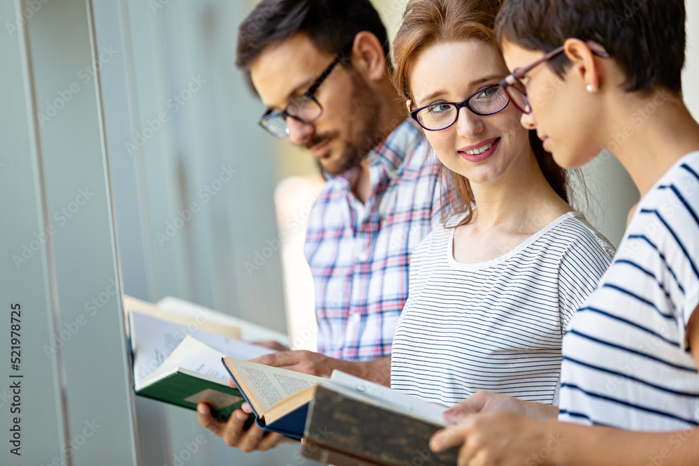 Education campus friendship people concept. Group of happy students studying together in library.