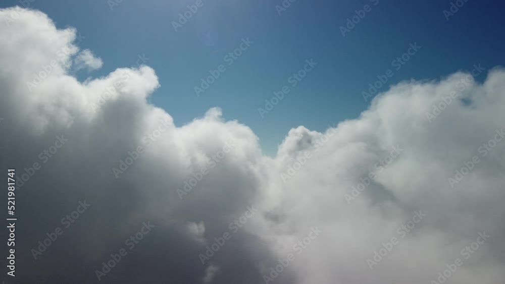 Aerial view. The drone flies over foggy and fluffy clouds. Blue sky sun and sea fog. Abstract aerial nature summer ocean sunset sea and sky background. Vacation, vacation and holiday concept