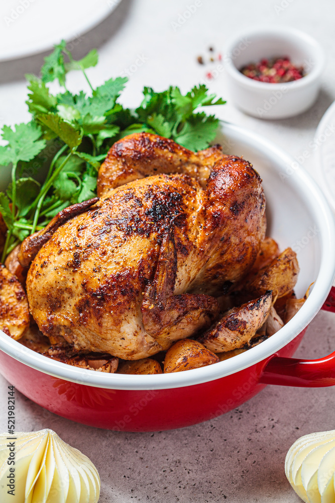 Christmas cooked chicken with potatoes in red pot. Festive homemade food concept. Christmas cooked chicken with potatoes in red pot. Festive homemade food concept.