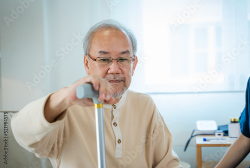 Nurse helps senior man practice walking at nursing home,Caregiver serve physical therapy for older patient to exercise and practice walking on walker or cane.