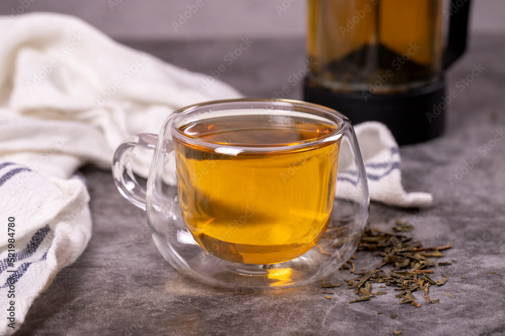 Green tea. Green tea brewed with French press on a dark background. Healthy drinks. Herbal tea concept. close up Green tea. Green tea brewed with French press on a dark background. Healthy drinks. Herbal tea concept. close up