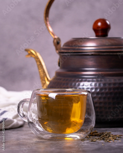 Green tea. Green tea brewed with copper teapot on dark background. Healthy drinks. Herbal tea concept. close up
