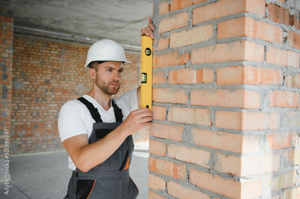 Portrait of handsome male builder in overalls and hard hat Portrait of handsome male builder in overalls and hard hat
