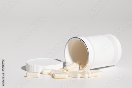 Mockup of isolated opened plastic medicine bottle, with pills, with screw cap and blank label for packaging design, on white background, real studio photo product, no 3D