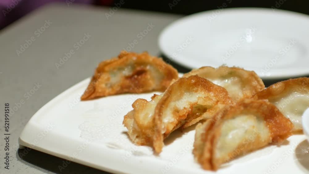 using chopstick pick up gyoza - fried wonton from the plate using chopstick pick up gyoza - fried wonton from the plate