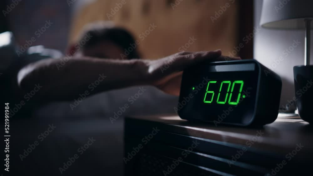 Man Wakes Up, Turns off Alarm Clock with Frustration. Early Rising Productive Man Ready Start a Day full of New Problems. Focus on the Clock Showing Six A.M. Bedside Nightstand bedroom Apartment