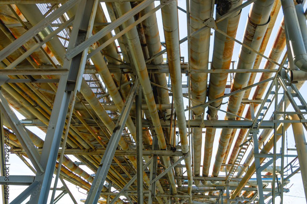 An overpass with pipes at an oil refinery. Transportation of chemical products through pipes at a chemical industry enterprise. Pipeline with dangerous chemicals.