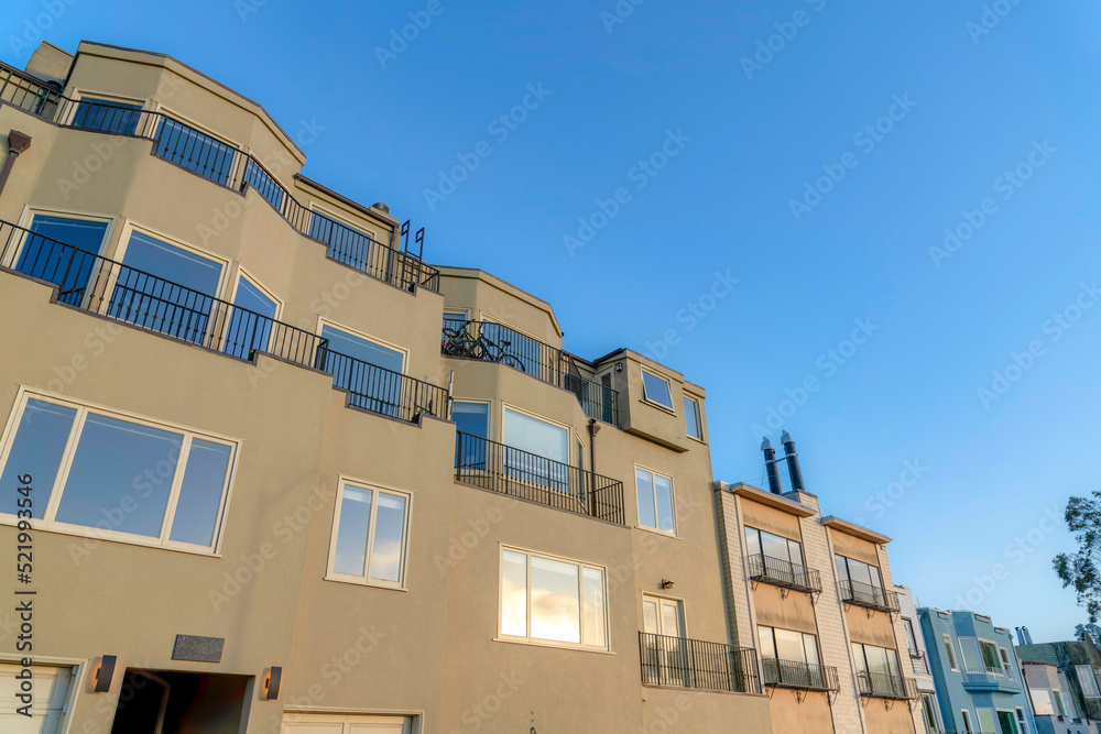 Low angle view of an apartment building with reflective windows and balconies in San Francisco, CA
