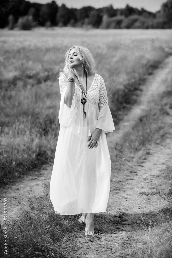 Ethnic hippie woman posing in boho long white lace dress at nature. Concept of ethnos style Ethnic hippie woman posing in boho long white lace dress at nature. Concept of ethnos style