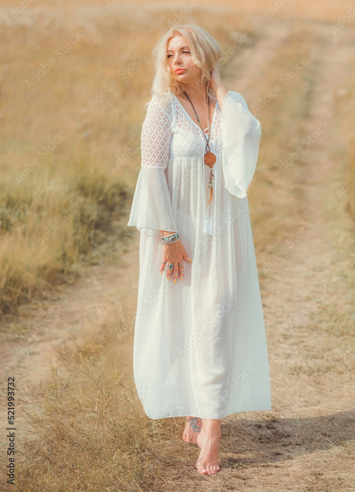 Ethnic hippie woman posing in boho long white lace dress at nature. Concept of ethnos style Ethnic hippie woman posing in boho long white lace dress at nature. Concept of ethnos style