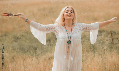 Ethnic hippie woman posing in boho long white lace dress at nature. Concept of ethnos style
