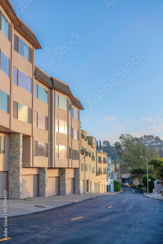 Row of apartment buildings with attached garages near the road in San Francisco, CA