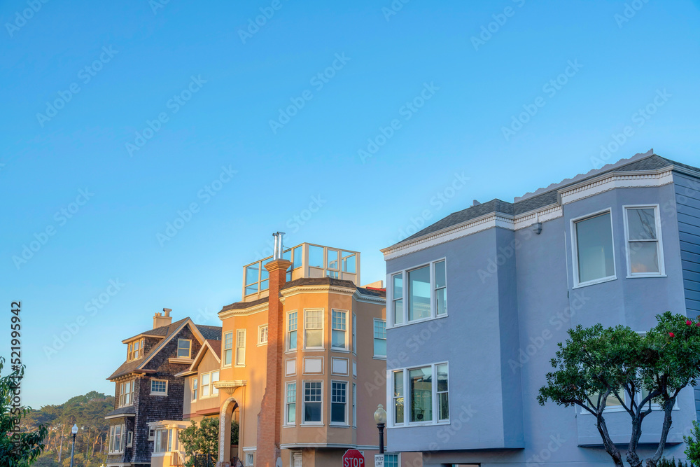 Large residential house buildings near the street lamps and stop sign in San Francisco, California