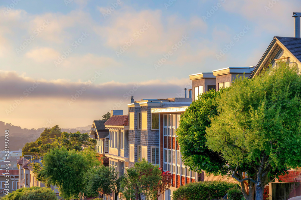 Residential buildings with glass windows with a reflection of the sunset sky in San Francisco, CA Residential buildings with glass windows with a reflection of the sunset sky in San Francisco, CA