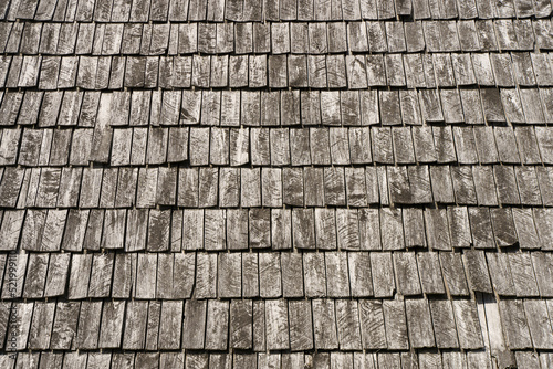 Old wooden roof tiles on the roof of a village house background