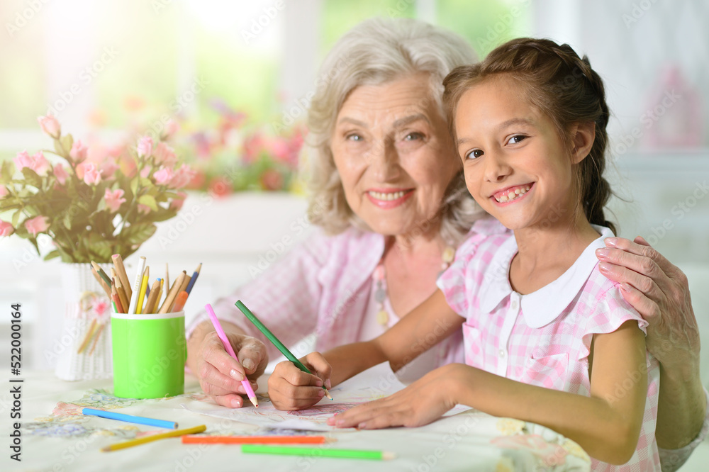 Portrait of a cute little girl drawing with her grandmother Portrait of a cute little girl drawing with her grandmother