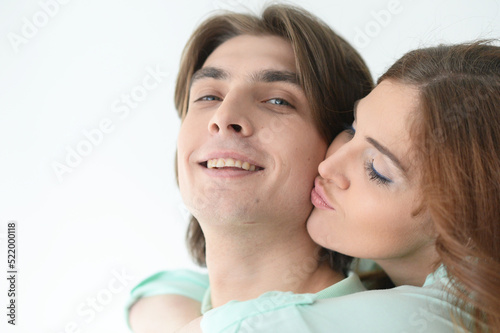 Close up portrait of happy young couple embracing at home