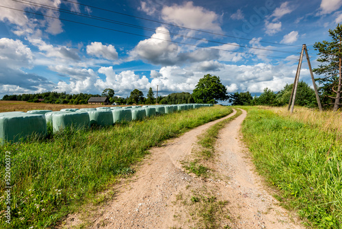 Countryside road among harvested cereals, agricultural landscape