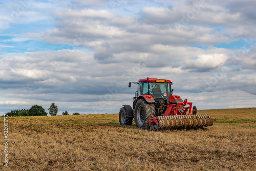 Tractor in european countryside. Harvest season.