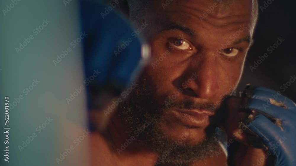 Male fighter works out in the dark gym Male fighter works out in the dark gym