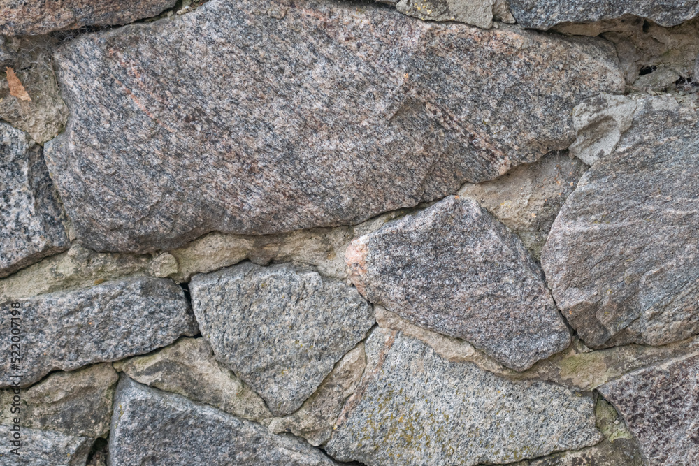 Close up of big grey stone wall with varishaped pieces
