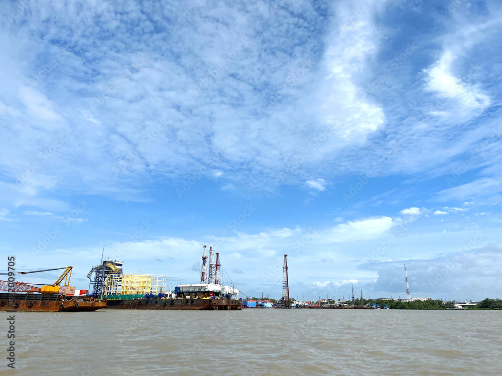 Large cargo ship loading in the ocean background with the blue sky and white cloudy landscape,Logistic transportation concept