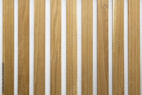 Wooden slats on white wall. Natural oak wood lath textured background. photo