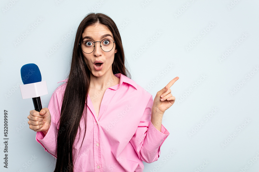 Young caucasian tv presenter woman isolated on blue background pointing to the side Young caucasian tv presenter woman isolated on blue background pointing to the side