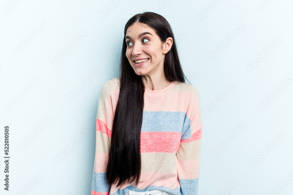 Young caucasian woman isolated on blue background laughs and closes eyes, feels relaxed and happy. Young caucasian woman isolated on blue background laughs and closes eyes, feels relaxed and happy.