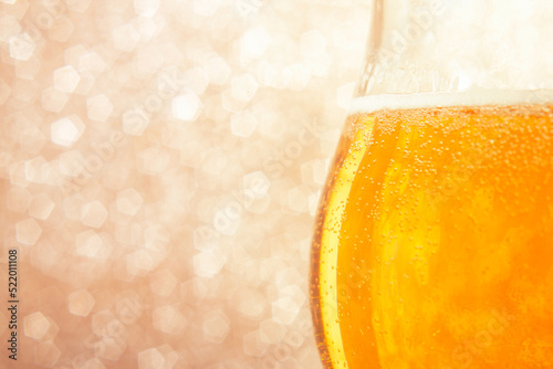Beer in a pub or bar, gold color  Beer in a glass on a shiny background