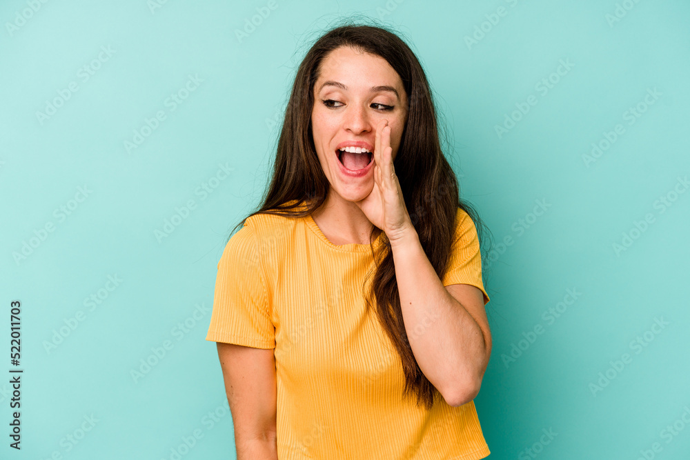 Young caucasian woman isolated on blue background shouting excited to front.