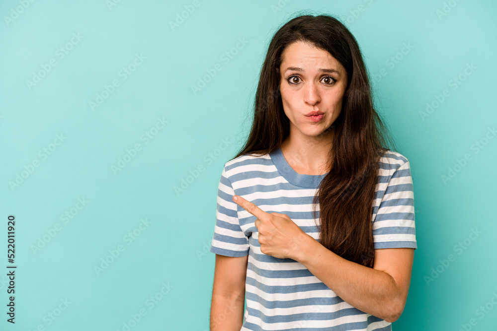 Young caucasian woman isolated on blue background pointing to the side Young caucasian woman isolated on blue background pointing to the side