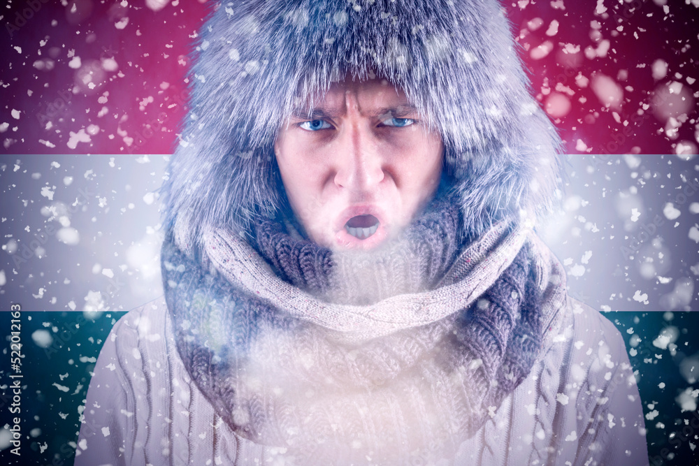 Isolate. Cold weather. Bask. A man in a fur hat and scarf warms his hands with his mouth. It's winter time Isolate. Cold weather. Bask. A man in a fur hat and scarf warms his hands with his mouth. It's winter time