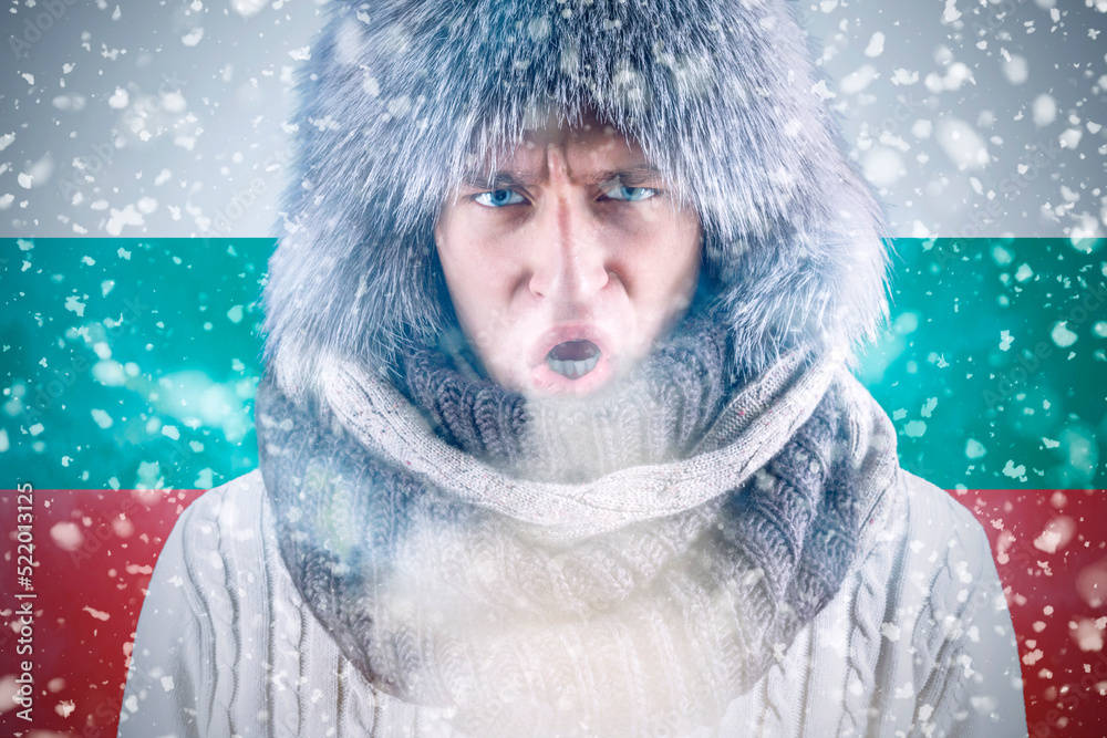 Isolate. Cold weather. Bask. A man in a fur hat and scarf warms his hands with his mouth. It's winter time Isolate. Cold weather. Bask. A man in a fur hat and scarf warms his hands with his mouth. It's winter time
